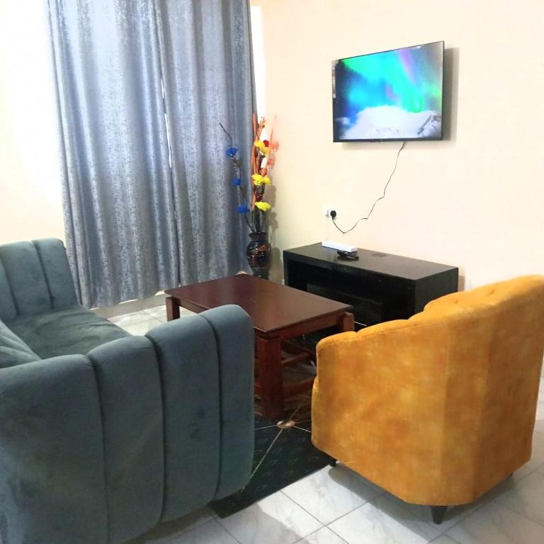 KakamegaMilly's homes的带沙发、桌子和电视的客厅