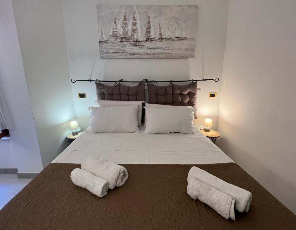 萨萨里Sassari Apartments - Maestrale的一间卧室配有一张大床和两条毛巾