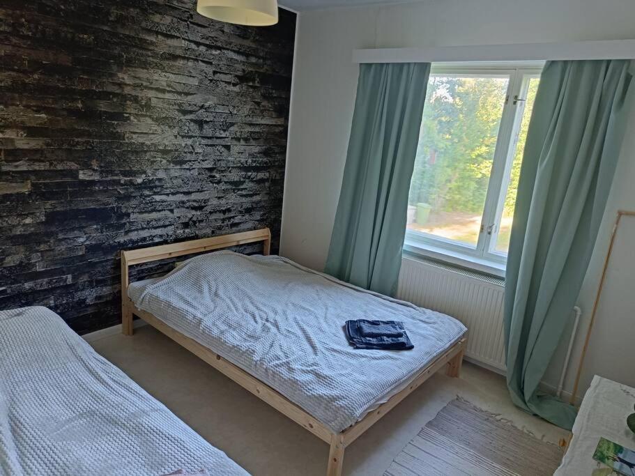 瓦尔考斯Rauhallinen kaksio, puusauna käytettävissä的一间小卧室,配有床和窗户