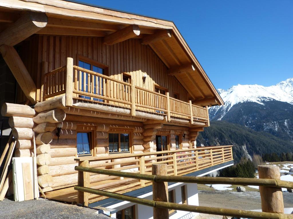 乌姆豪森Holzberghof的小木屋设有阳台,覆盖着雪覆盖的山脉