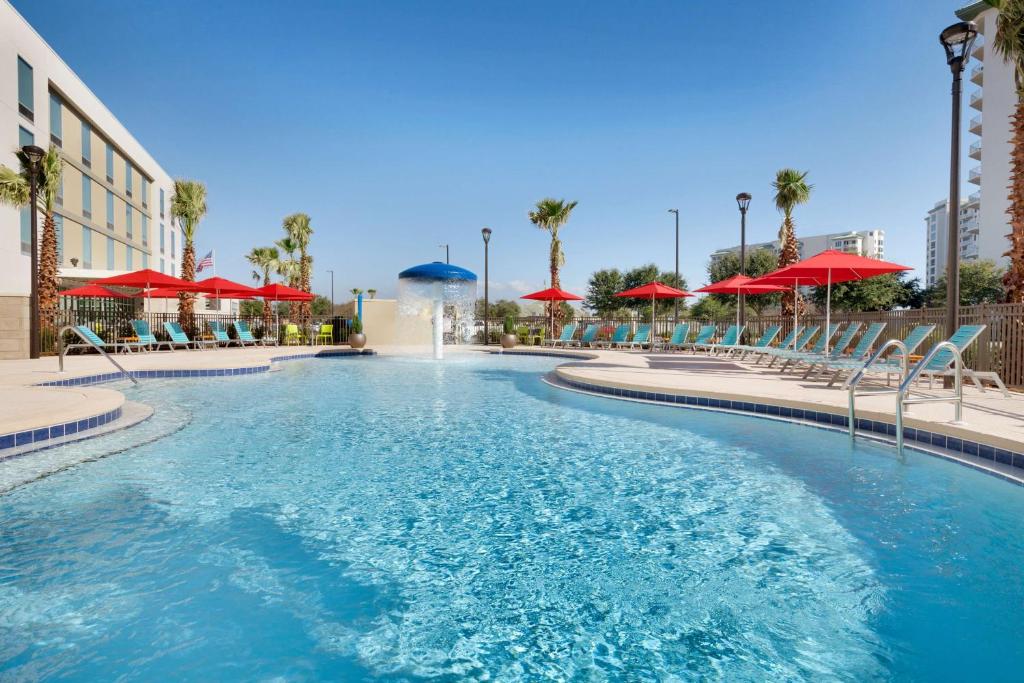 德斯坦德斯坦希尔顿欣庭套房酒店 的一个带红伞的度假村的游泳池