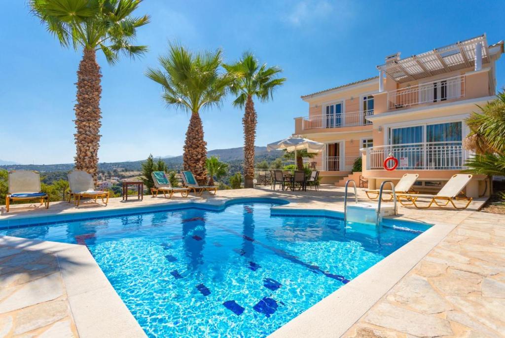圣特里亚斯Villa Astro的一座别墅前方的棕榈树游泳池