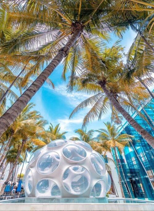 迈阿密Stanza Hearth of Miami Design District and Wynwood, Parking, Laundry, Workstation, Fully equipped Apts, 24/7 Guest support #2的棕榈树前的白色雕塑