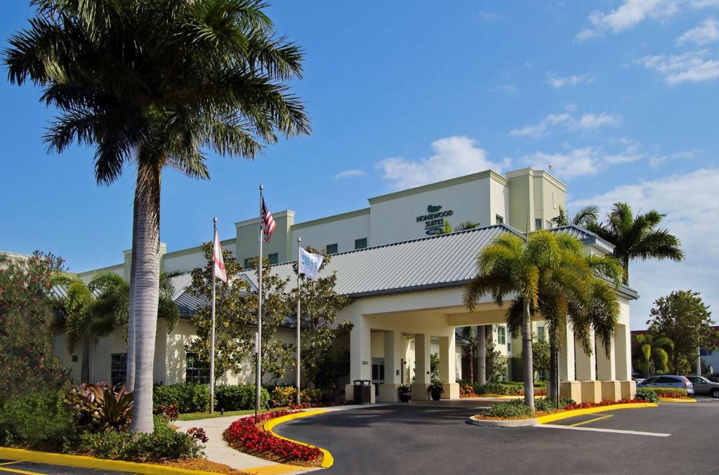 达尼亚滩劳德代尔堡机场邮轮码头希尔顿惠庭套房酒店的一座楼前有棕榈树的酒店