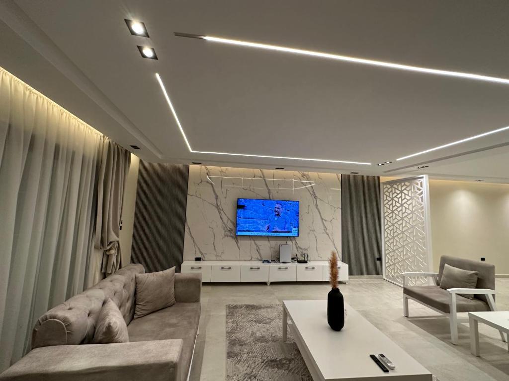 开罗Happiness Apartment的客厅配有沙发和墙上的电视