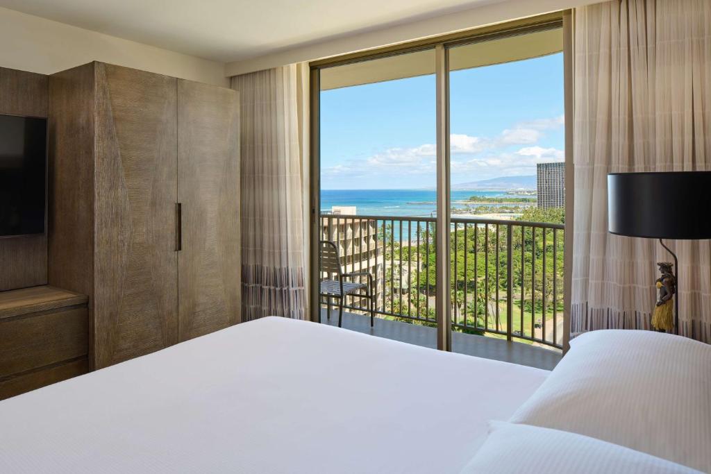 檀香山Embassy Suites by Hilton Waikiki Beach Walk的一间卧室设有一张床和一个大窗户