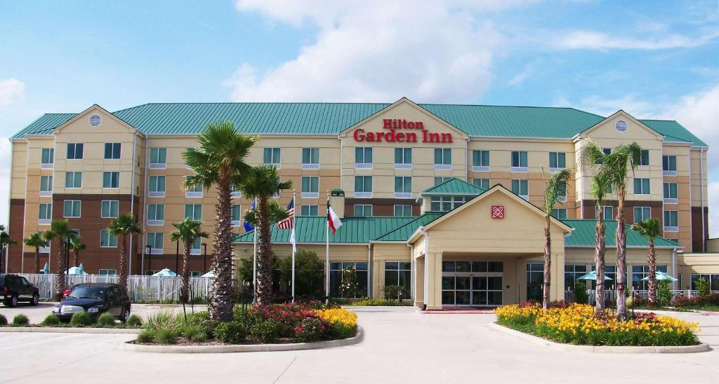 皮尔兰Hilton Garden Inn Houston-Pearland的停车场内棕榈树的酒店花园旅馆