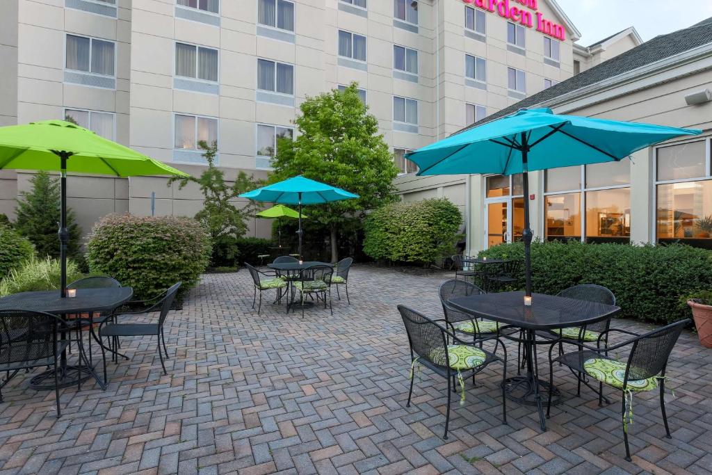 南乌特纳纽埃特花园旅馆希尔顿酒店的酒店前方设有带桌子和遮阳伞的庭院。