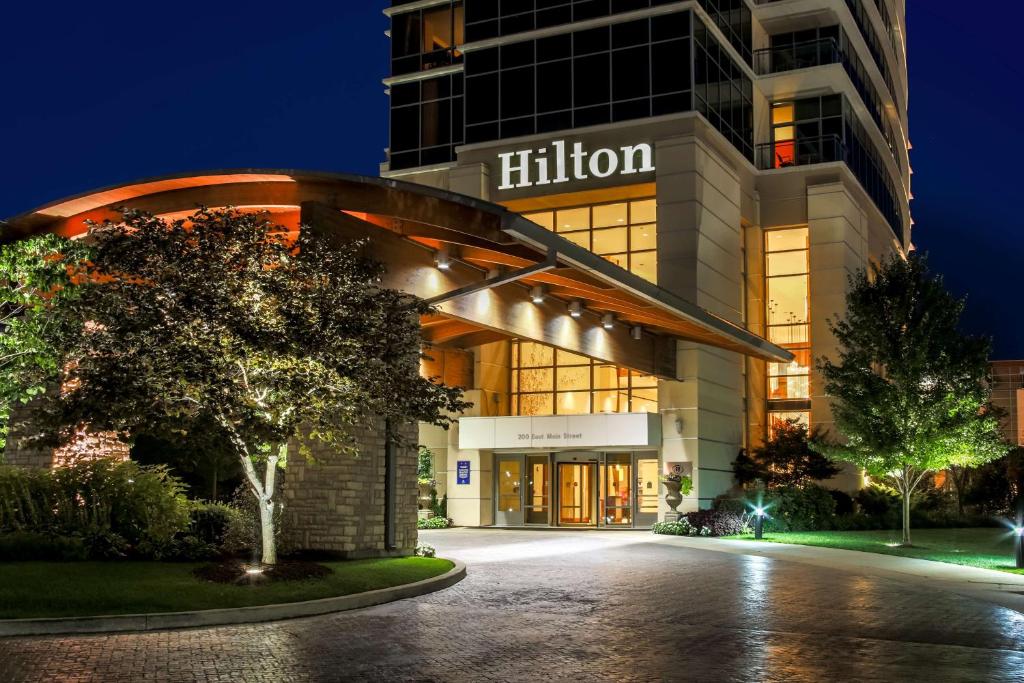 布兰森Hilton Branson Convention Center的一座黑尔顿建筑,晚上与一座建筑