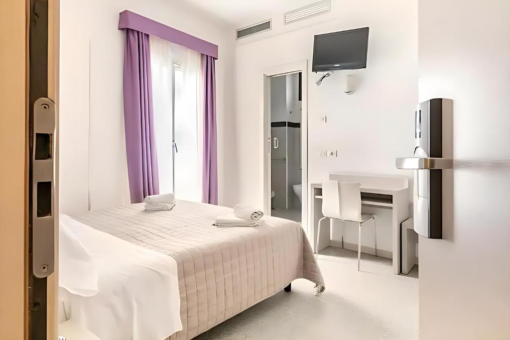 里米尼Hotel Villa Argia Rimini Marina Centro的白色卧室配有床和书桌
