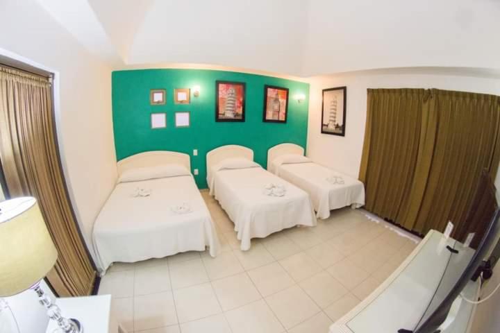 Iguala de la IndependenciaHOTEL OBREGON的一间设有三张床和绿色墙壁的客房