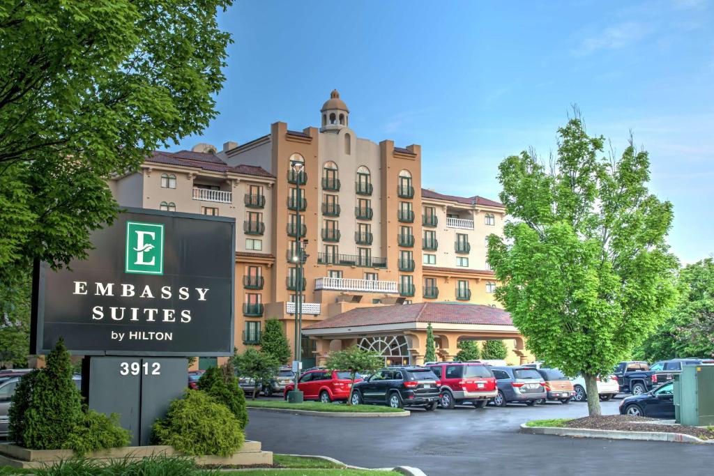 印第安纳波利斯Embassy Suites by Hilton Indianapolis North的代表使馆套房在停车场前的标志