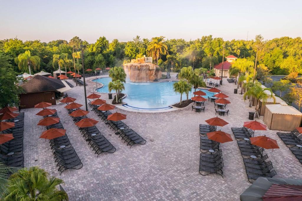 奥兰多Hilton Vacation Club Mystic Dunes Orlando的享有带遮阳伞的度假村游泳池的空中景致