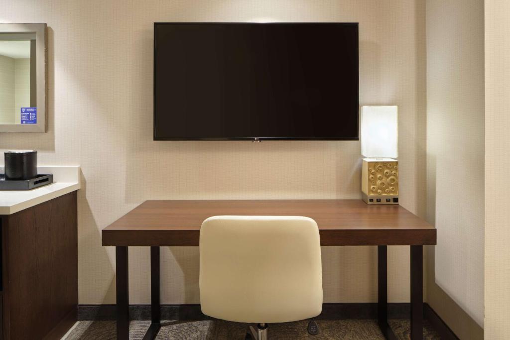 卡波雷卡珀累欧胡岛 - 希尔顿大使馆套房酒店 - 供应免费早餐的客房设有一张桌子、一把椅子和一台电视