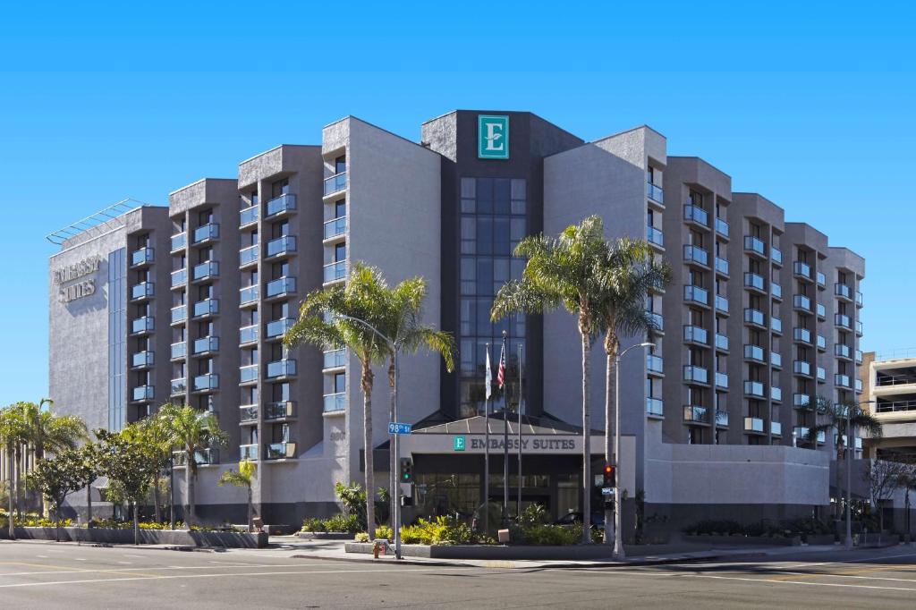 洛杉矶洛杉矶国际机场北使馆套房酒店的一座棕榈树环绕的大建筑