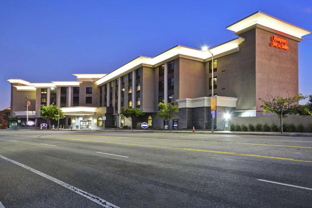 伯班克洛杉矶伯班克机场汉普顿套房酒店的一个大建筑前的一条空的街道