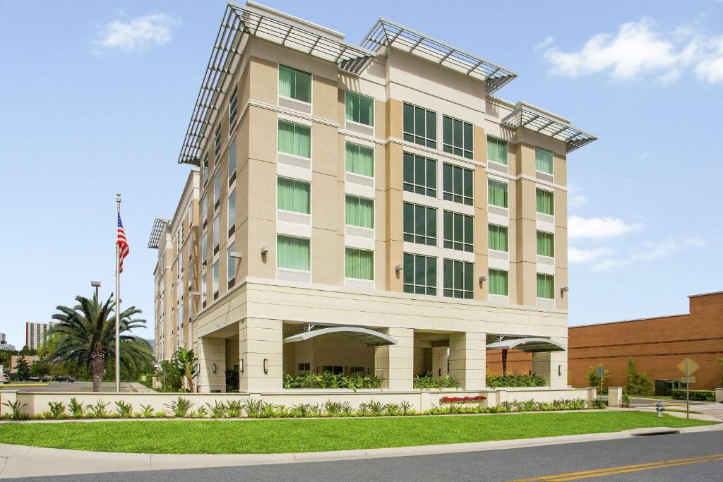 奥兰多奥兰多/市中心南医疗中心汉普顿套房酒店 的前面有旗帜的高大的白色建筑