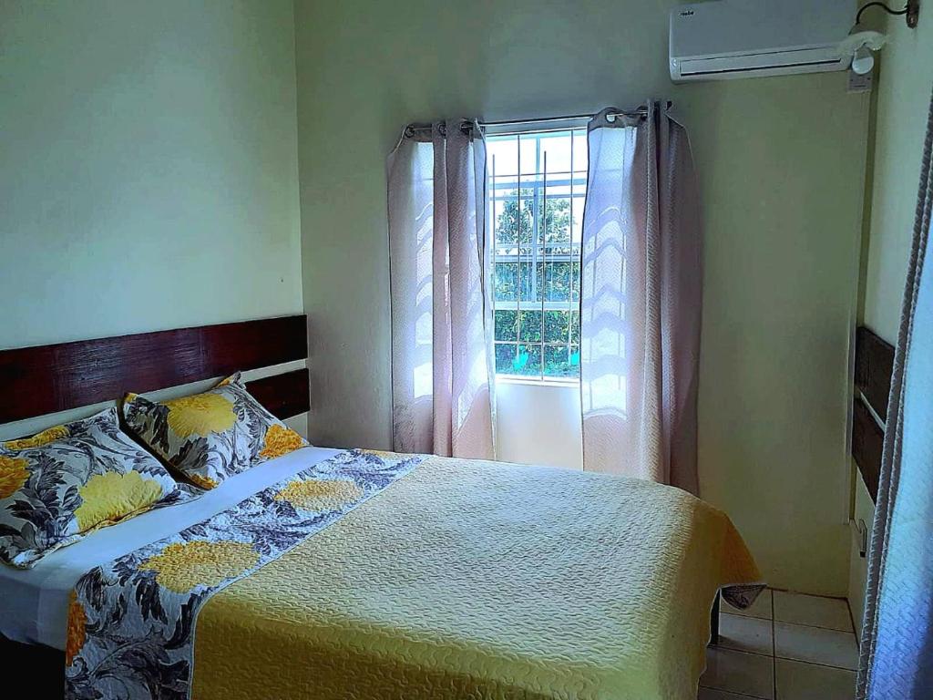 LaborieJuju's Cottage with magnificent views的一间卧室设有一张床和一个窗口