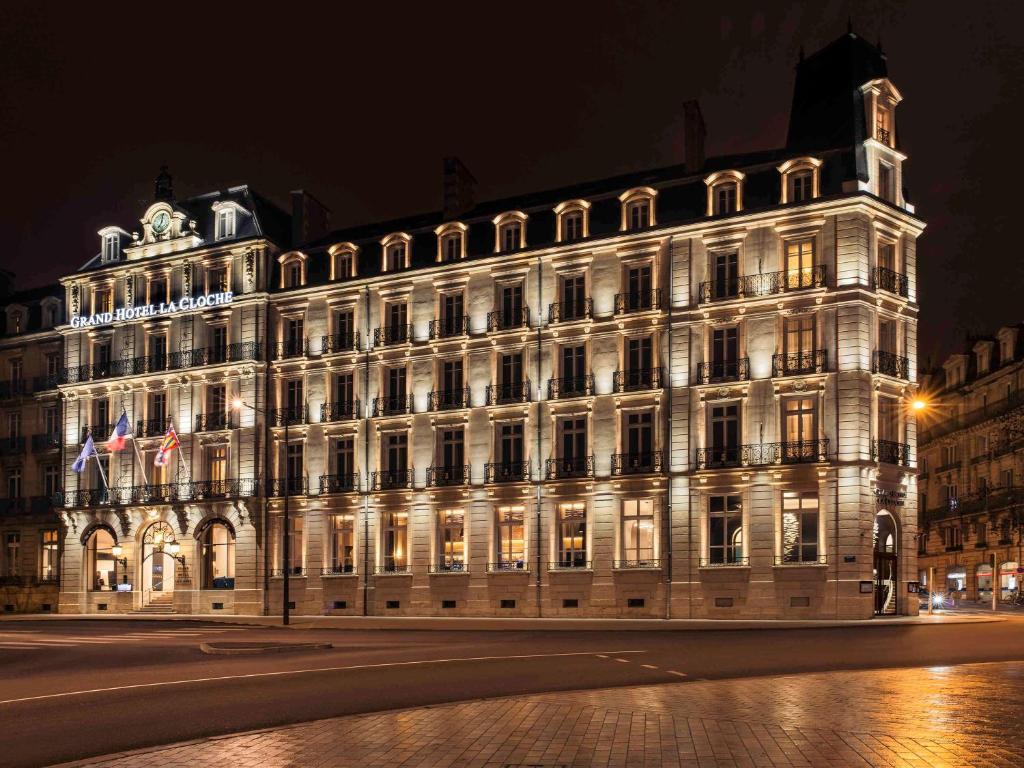 第戎Grand Hotel La Cloche Dijon - MGallery的一座在晚上有灯的大建筑