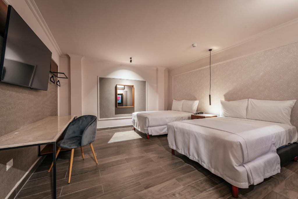 梅里达Hotel MID Project的酒店客房配有两张床和一张书桌