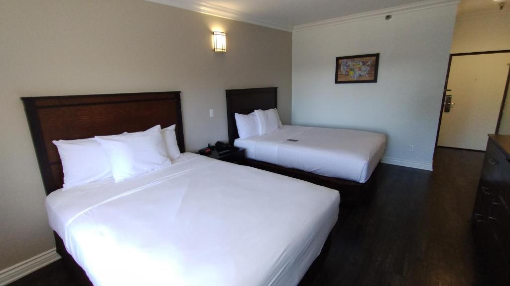 安大略Baymont by Wyndham Ontario的酒店客房,配有两张带白色床单的床