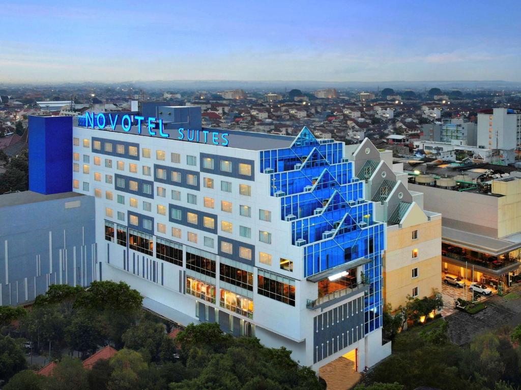 日惹Novotel Suites Yogyakarta Malioboro的享有建筑的空中景致,设有蓝色窗户