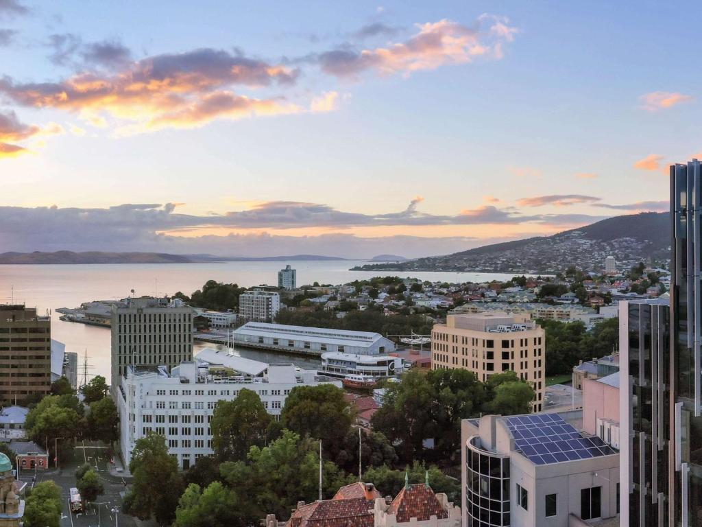 霍巴特Mövenpick Hotel Hobart的日落时分享有城市天际线的景致