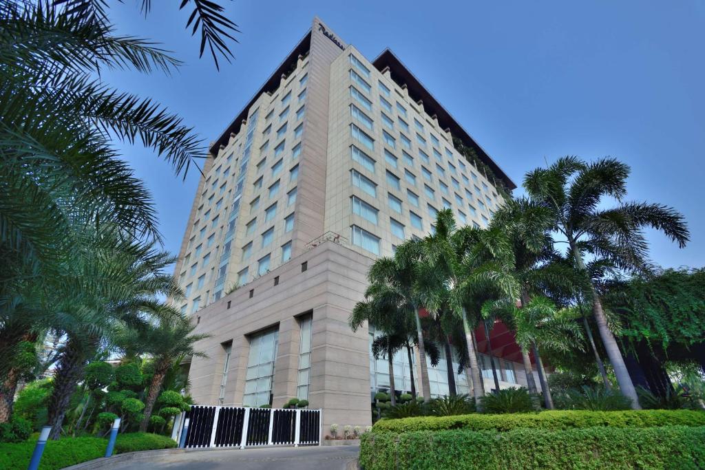 印多尔印多尔丽笙酒店的一座高大的建筑,前面有棕榈树