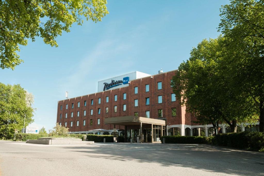 阿兰达斯德哥尔摩阿兰达阿兰迪亚丽笙酒店的街道前方的一座大型红砖建筑