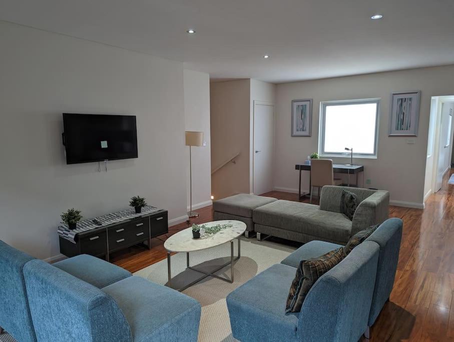 金斯顿Spacious 2 bedroom apartment @Kingston Foreshore的客厅配有2张蓝色沙发和电视