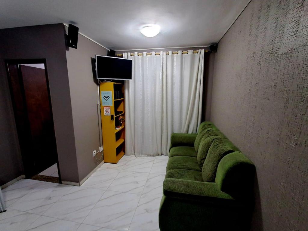 大普拉亚Apartamento Vidal con Wi-Fi Praia Grande Avi的客厅配有绿色沙发和电视