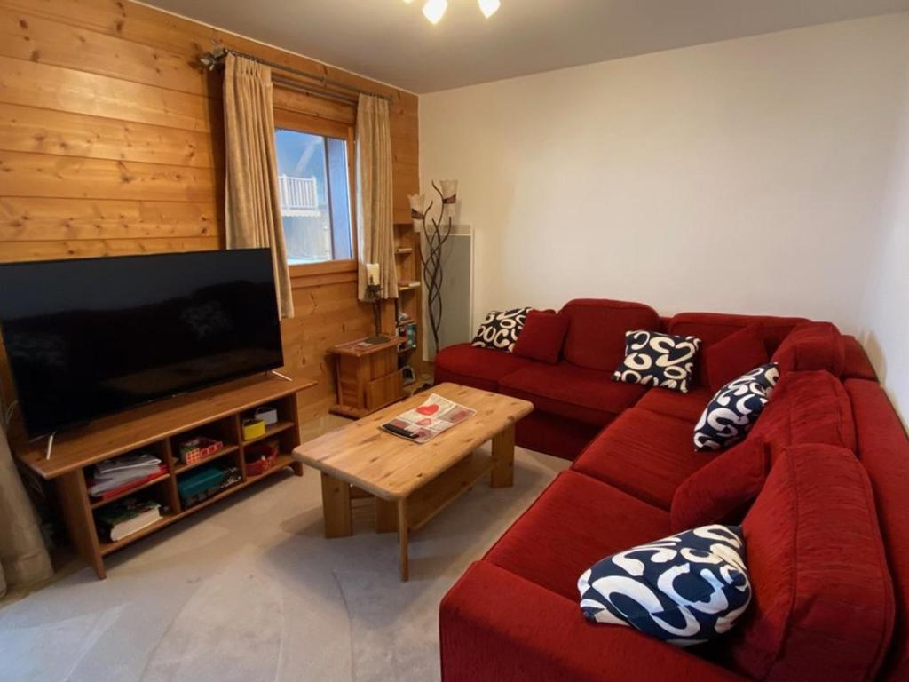克雷斯特沃朗Appartement Crest-Voland, 3 pièces, 6 personnes - FR-1-733-140的客厅配有红色沙发和平面电视
