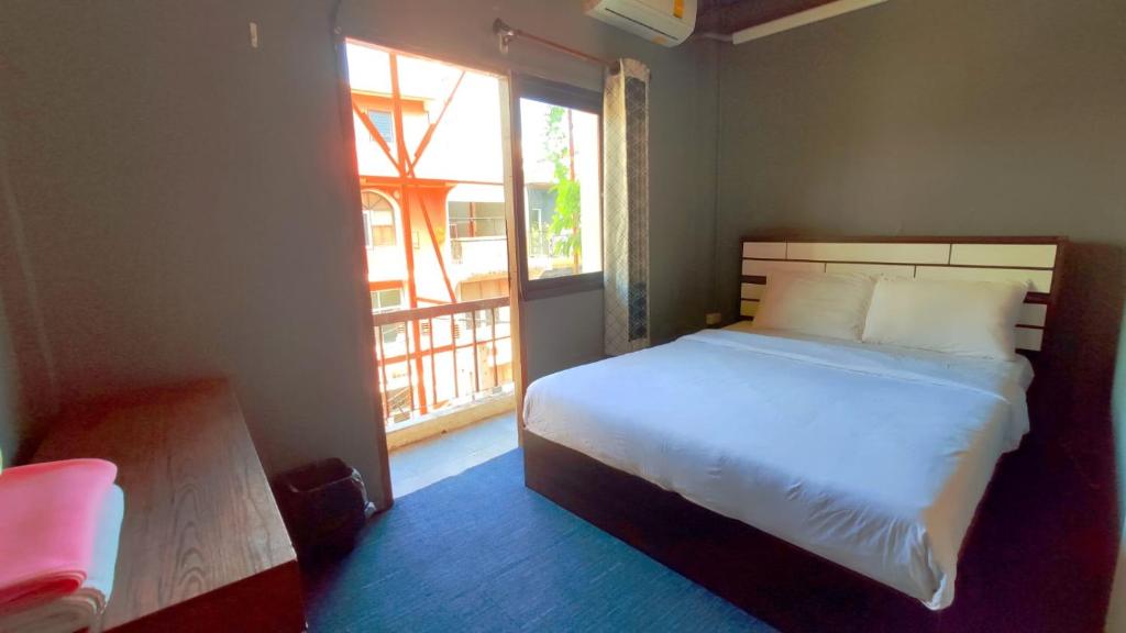 芭堤雅市中心Jurockotel的一间卧室设有一张床和一个大窗户