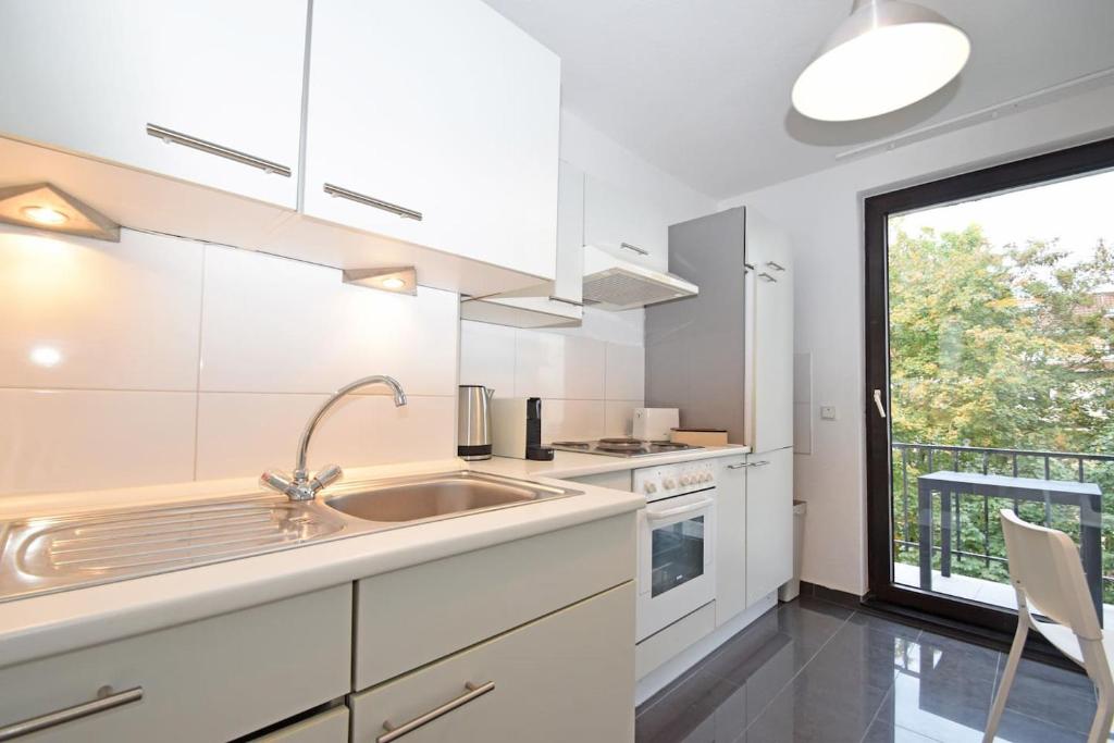 不莱梅Air Apartments 1的白色的厨房设有水槽和窗户