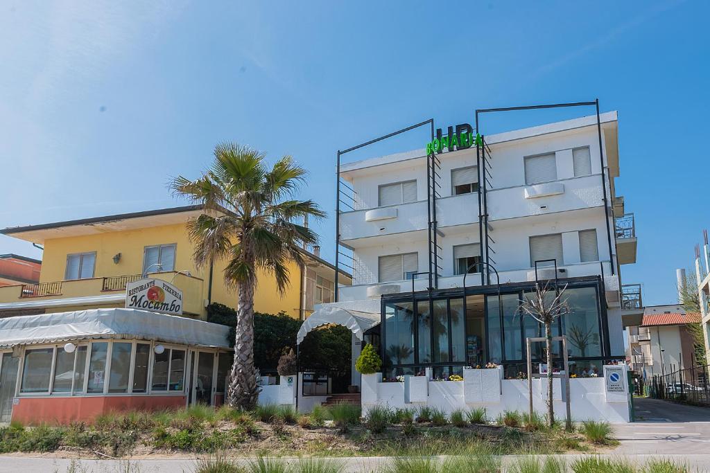 里米尼Hotel Bonaria的前面有棕榈树的建筑