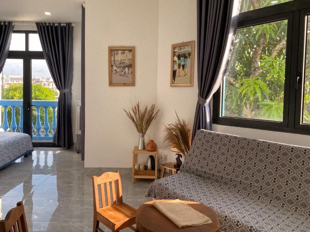 富国Homestay Sài Gòn的带沙发和大窗户的客厅