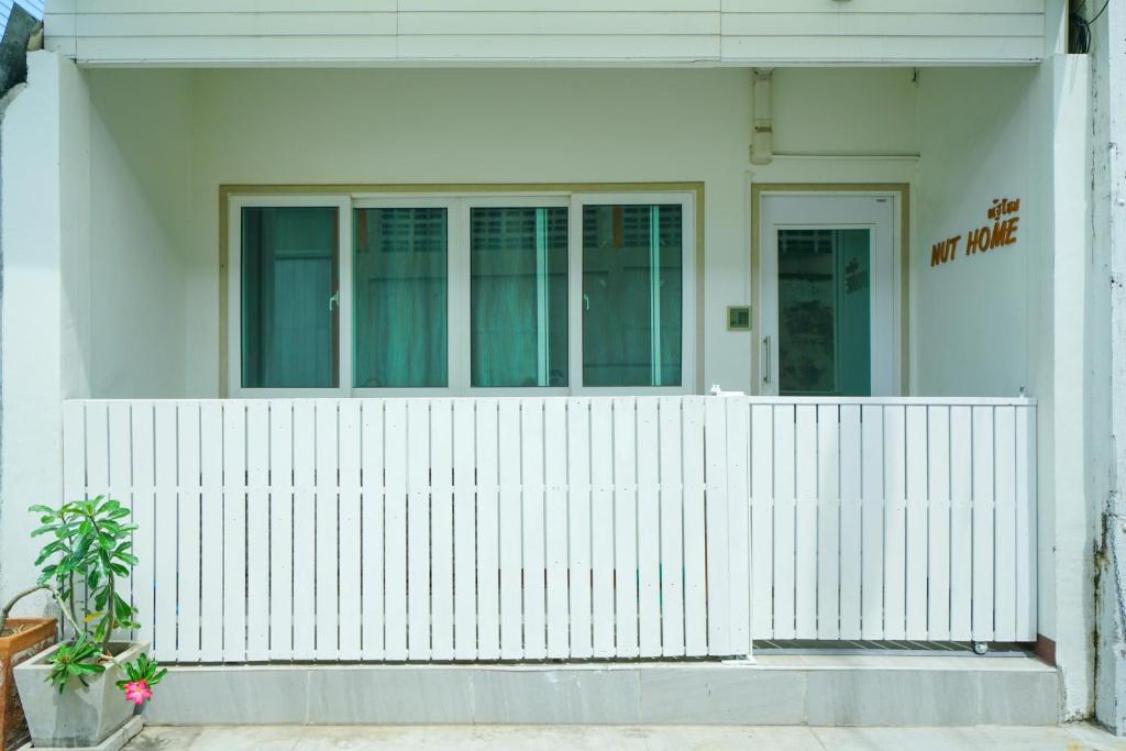 Ban KoNut Home Hostel的白色房子前面的白色围栏