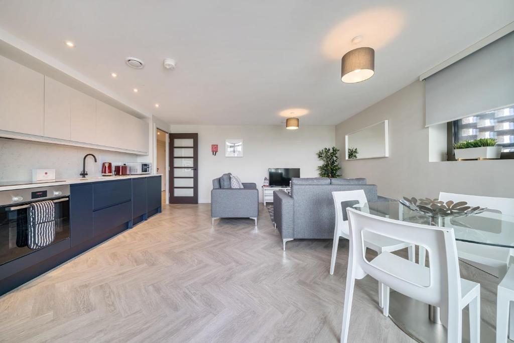 泰晤士河畔金斯顿Roomspace Serviced Apartments- Buttermere House的厨房以及带桌椅的起居室。