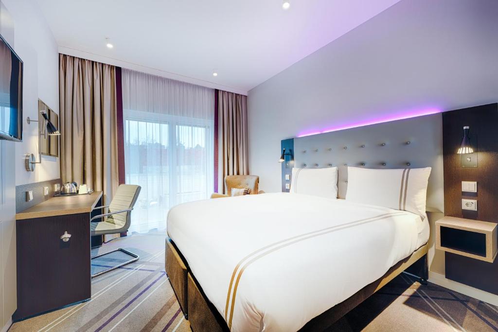 曼海姆Premier Inn Mannheim City Centre的酒店客房设有一张大床和一张书桌。