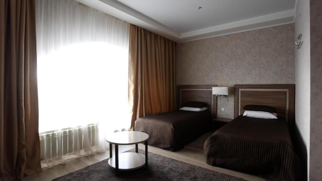 库斯塔奈Hotel Fessla的酒店客房设有两张床和窗户。