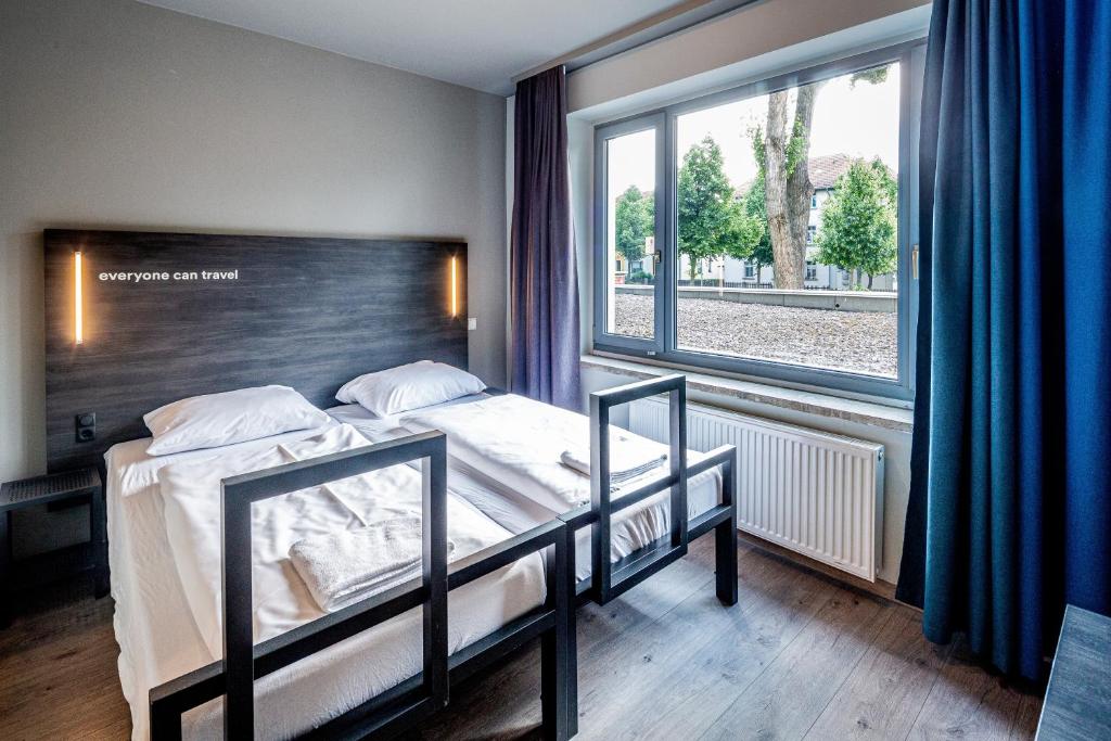 魏玛魏玛A&O酒店的一间卧室设有两张床和大窗户