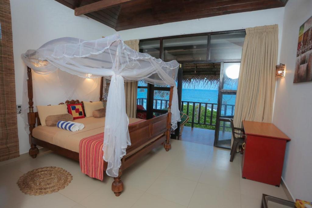 NetolpitiyaBlue Ocean Resort的一间卧室设有一张天蓬床,享有海景