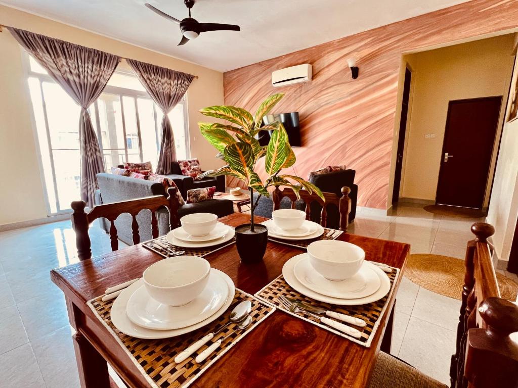 Kiembi SamakiAfrica Mbweni Apartment的一间带木桌和椅子的用餐室