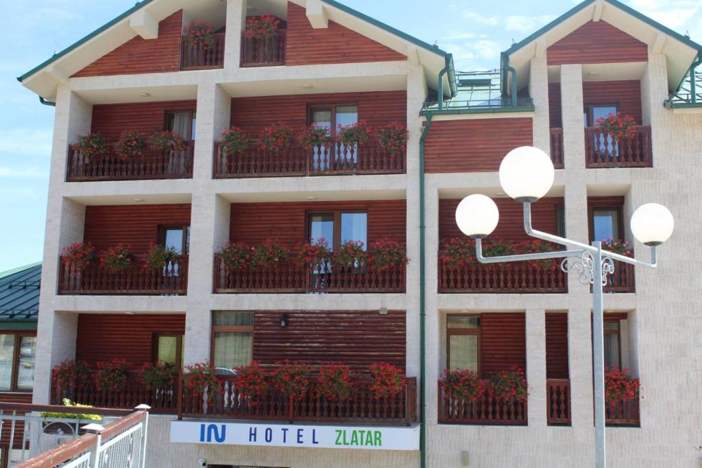 新瓦罗什IN Hotel Zlatar ex Zlatarski Biseri的酒店大楼的阳台设有花盒