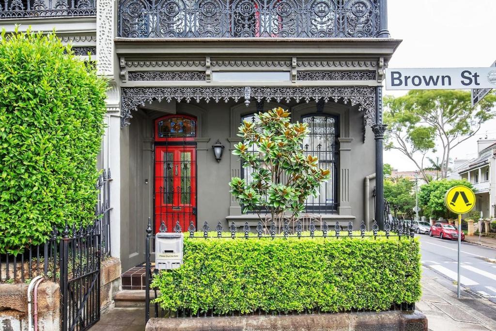 悉尼Refined Paddington Corner Terrace with Parking的一座有红门和绿 ⁇ 的房子