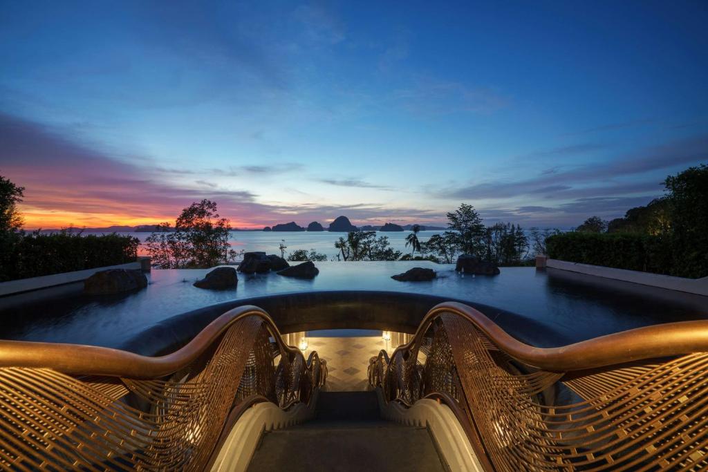 塔可克海滩Banyan Tree Krabi - SHA Extra Plus的日落时分享有海洋美景的游泳池