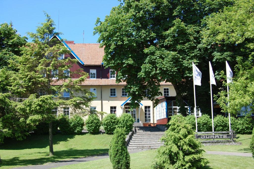 奈达Hotel Jurate的前面有旗帜的大房子