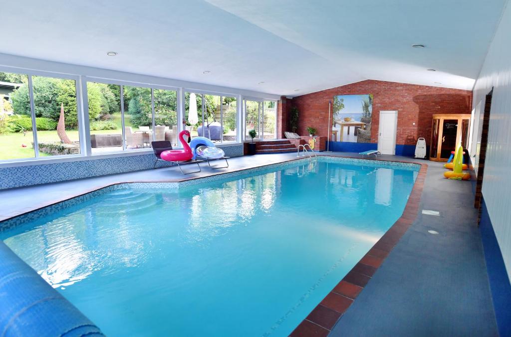 阿斯克Luxury property - Swimming Pool, Games Room & Hot Tub的大型客房带窗户,设有大型游泳池