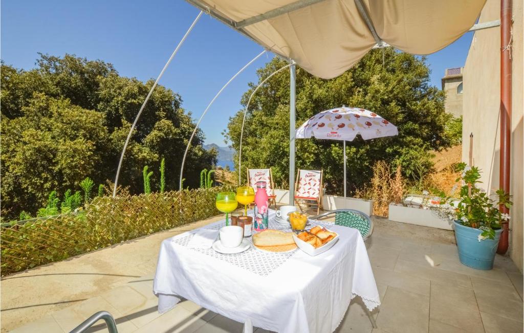 皮亚纳Awesome Apartment In Piana With Wifi的一张桌子,上面有食物和饮料,还有一把雨伞