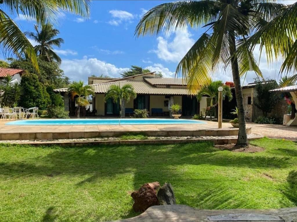 盖比姆Casa LUXO Guaibim的一座带游泳池和棕榈树的房子